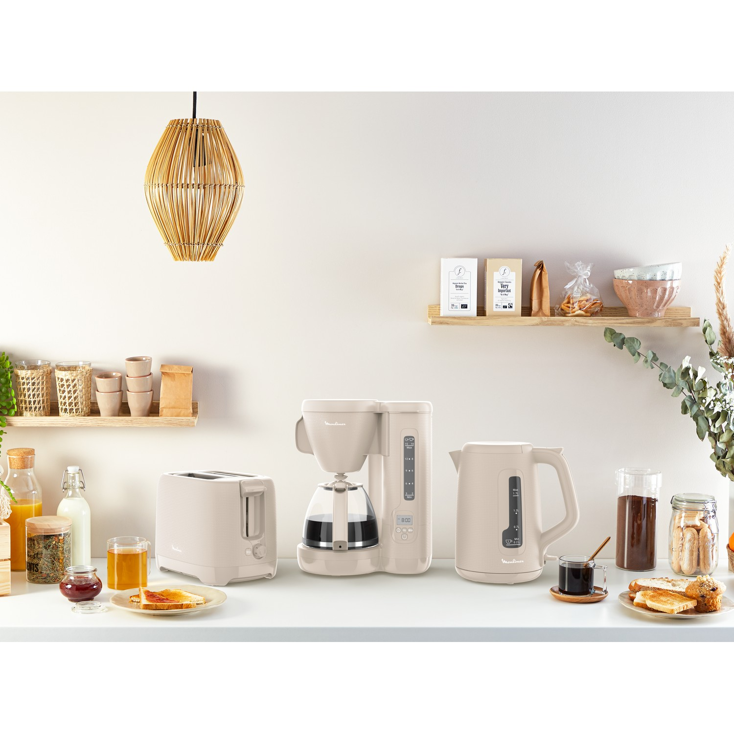 Kitchen appliances on a counter: toaster, coffee maker, kettle, with food items.