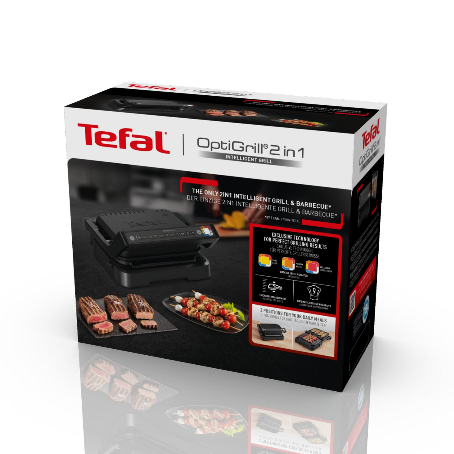Grill box. Grill, skewers, and steaks on a reflective black surface.