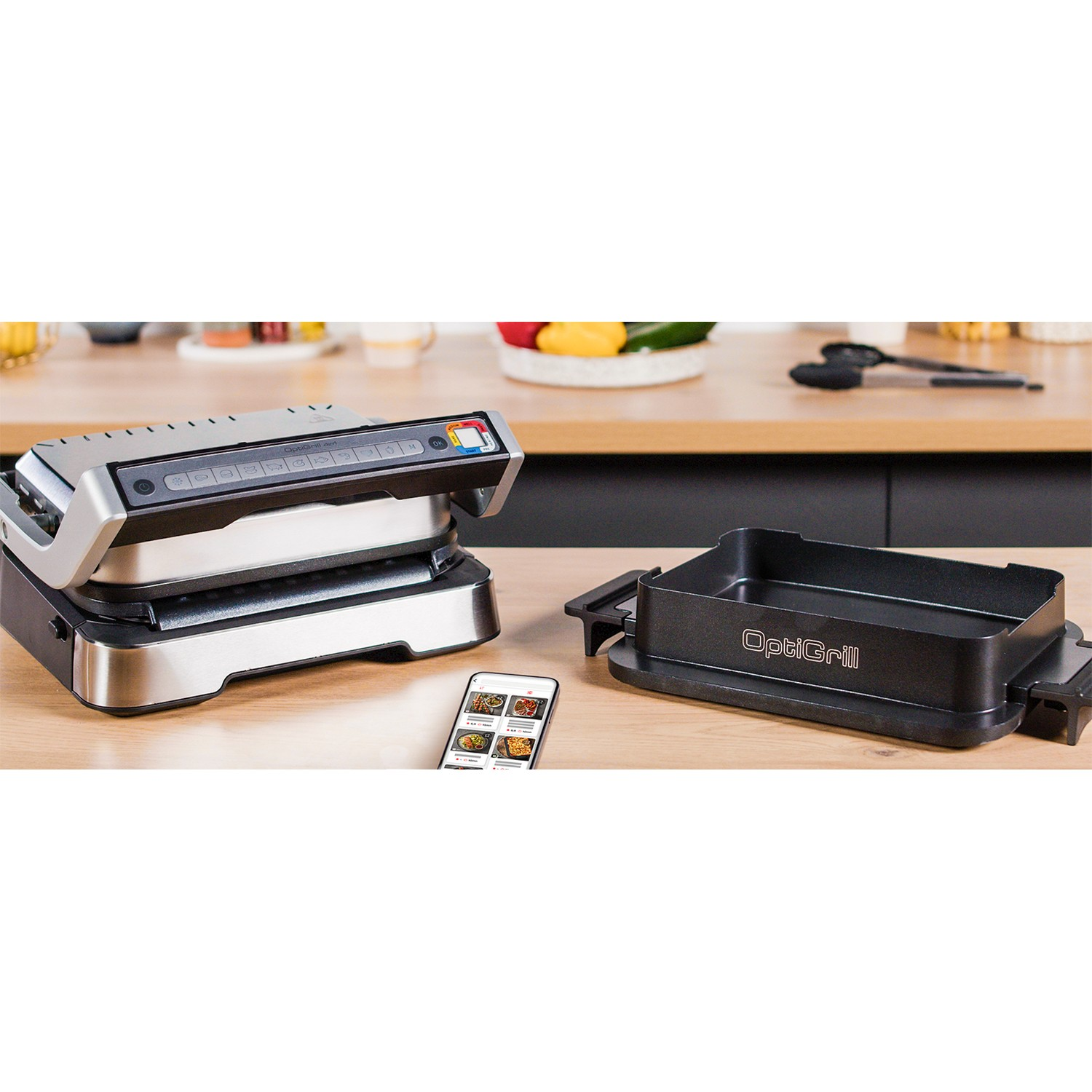 OptiGrill met smartphone met recepten. Grillplaten ernaast.
