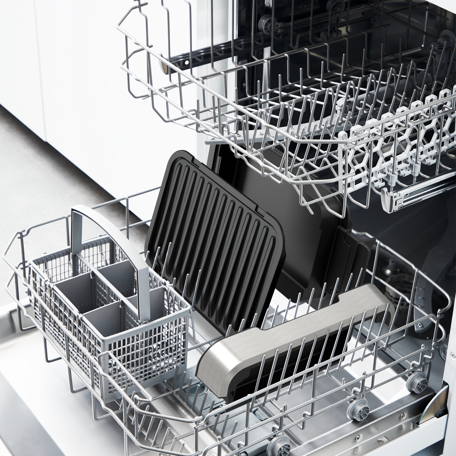 Vaatwasserinterieur met rekken, een zwart grill-achtig dienblad en een bestekmandje.