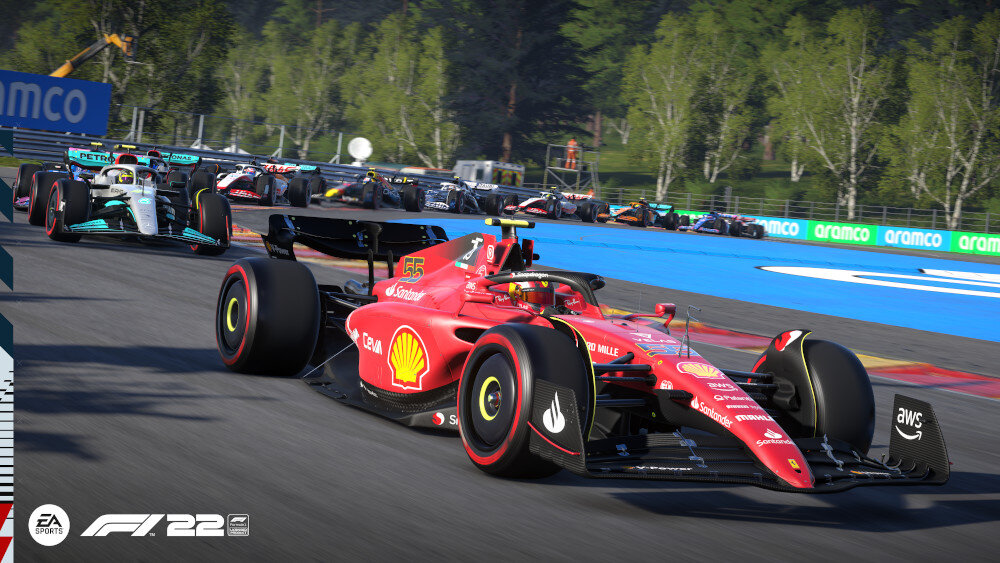 Scena z gry F1 2022, czerwone Ferrari prowadzi w wyścigu. Inne samochody w tle.