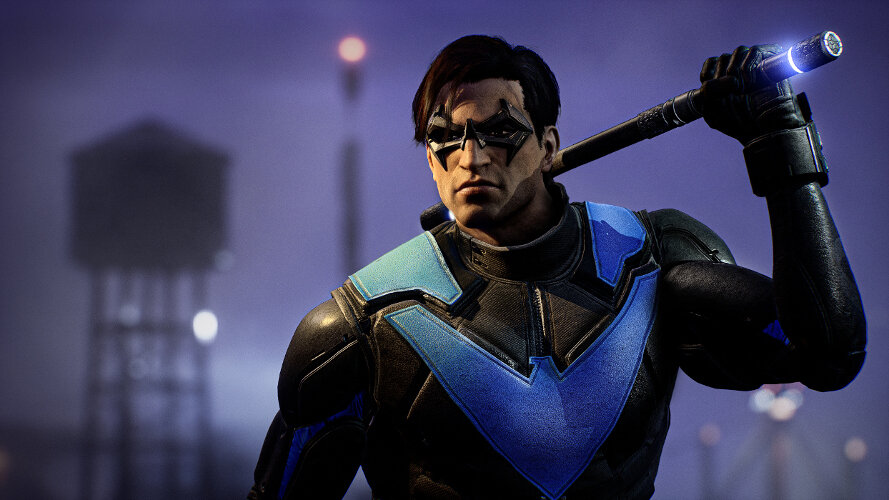 Nightwing z laską, w niebiesko-czarnym kostiumie. Wieża ciśnień w rozmytym tle.