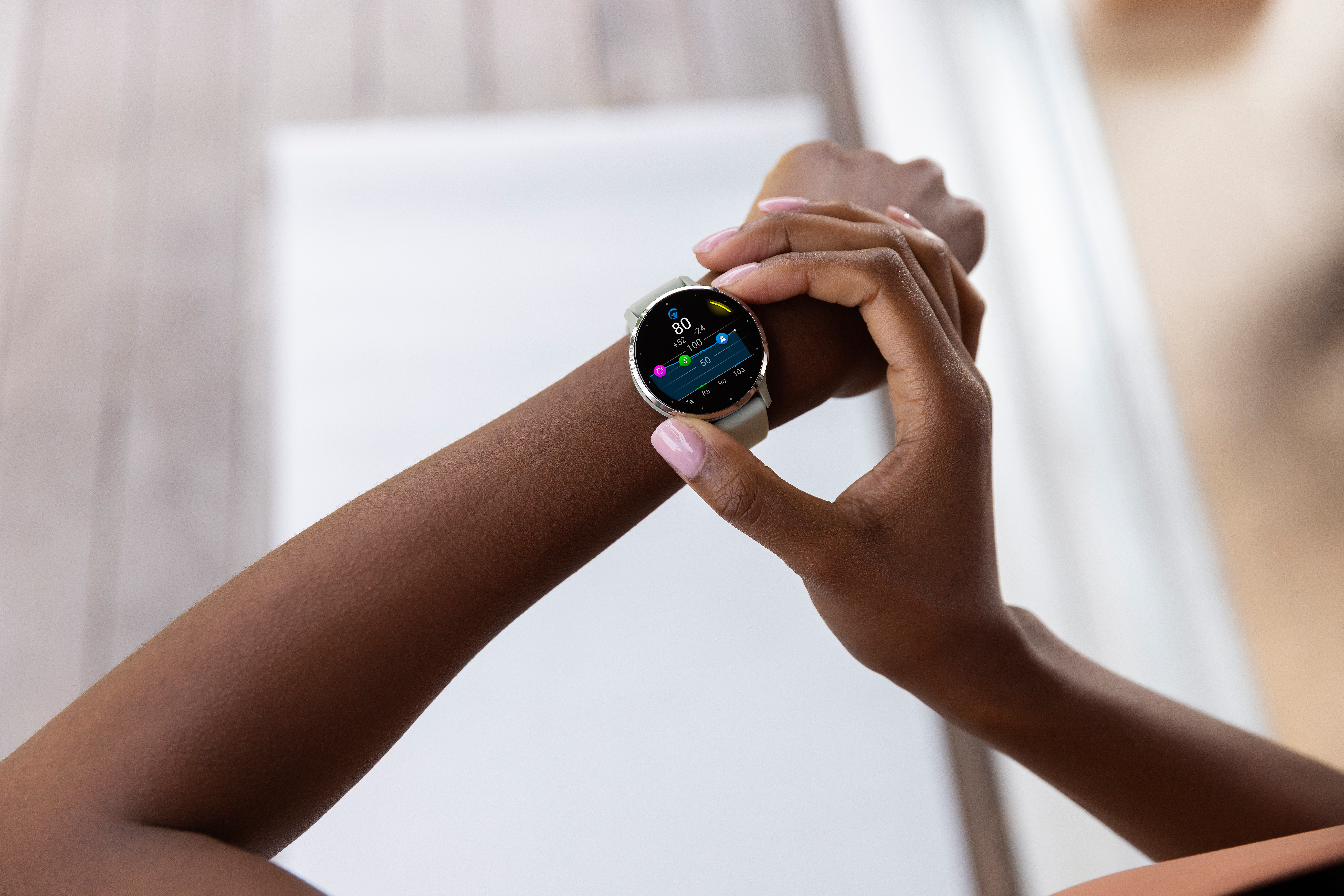 Eine Person, die eine Smartwatch am Handgelenk trägt. Die Uhr zeigt Gesundheitsmetriken an. Die Person hat dunkle Haut.