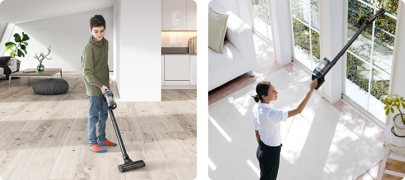 Ein Junge und eine Frau, die ein Haus saugen, einer auf einem Holzboden, die andere auf einem Teppichboden in der Nähe eines Fensters.