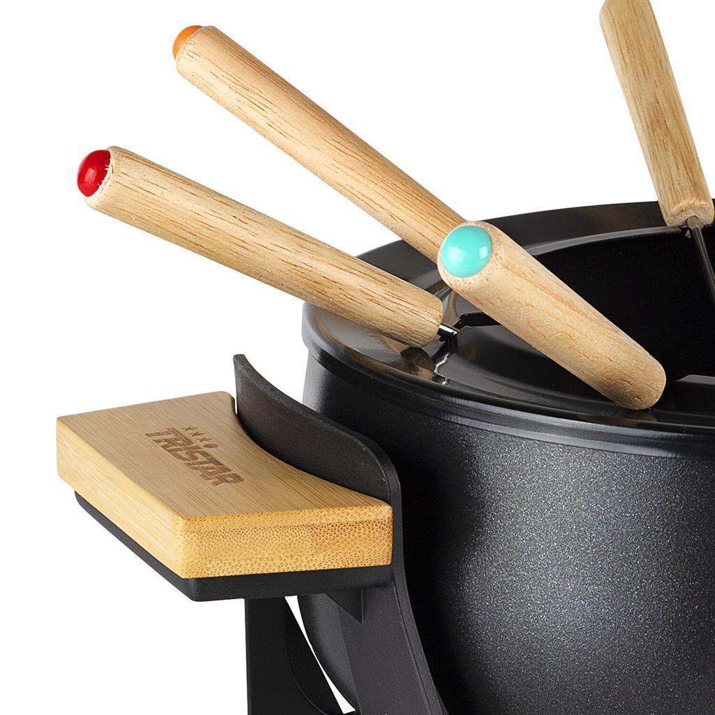 Fondue-Set mit Holzgriffen und farbigen Spitzen. Im Vordergrund steht ein schwarzer Topf mit einer Holzplattform. Mehrere Spieße sind sichtbar.