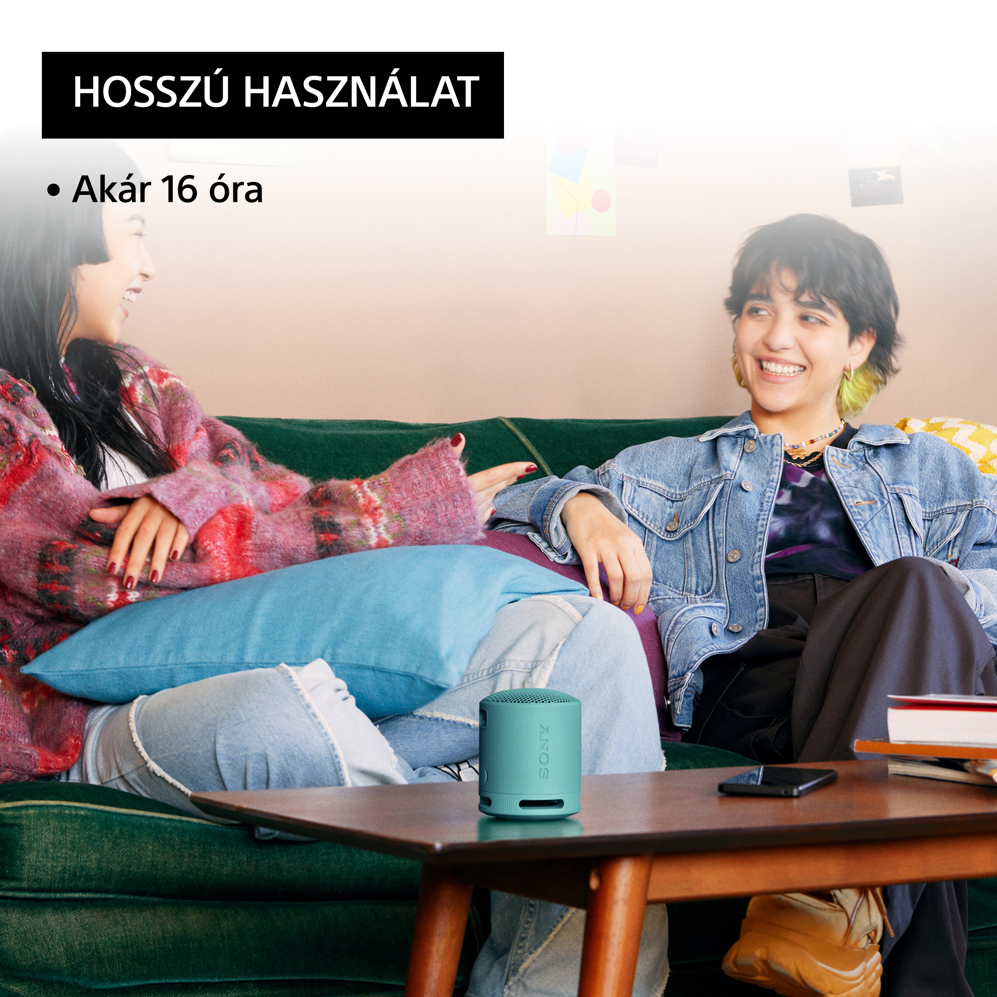 Két nő a kanapén, egy türkiz hangszóróval. A szöveg azt mondja: "Hosszú használat" és "Akár 16 óra".