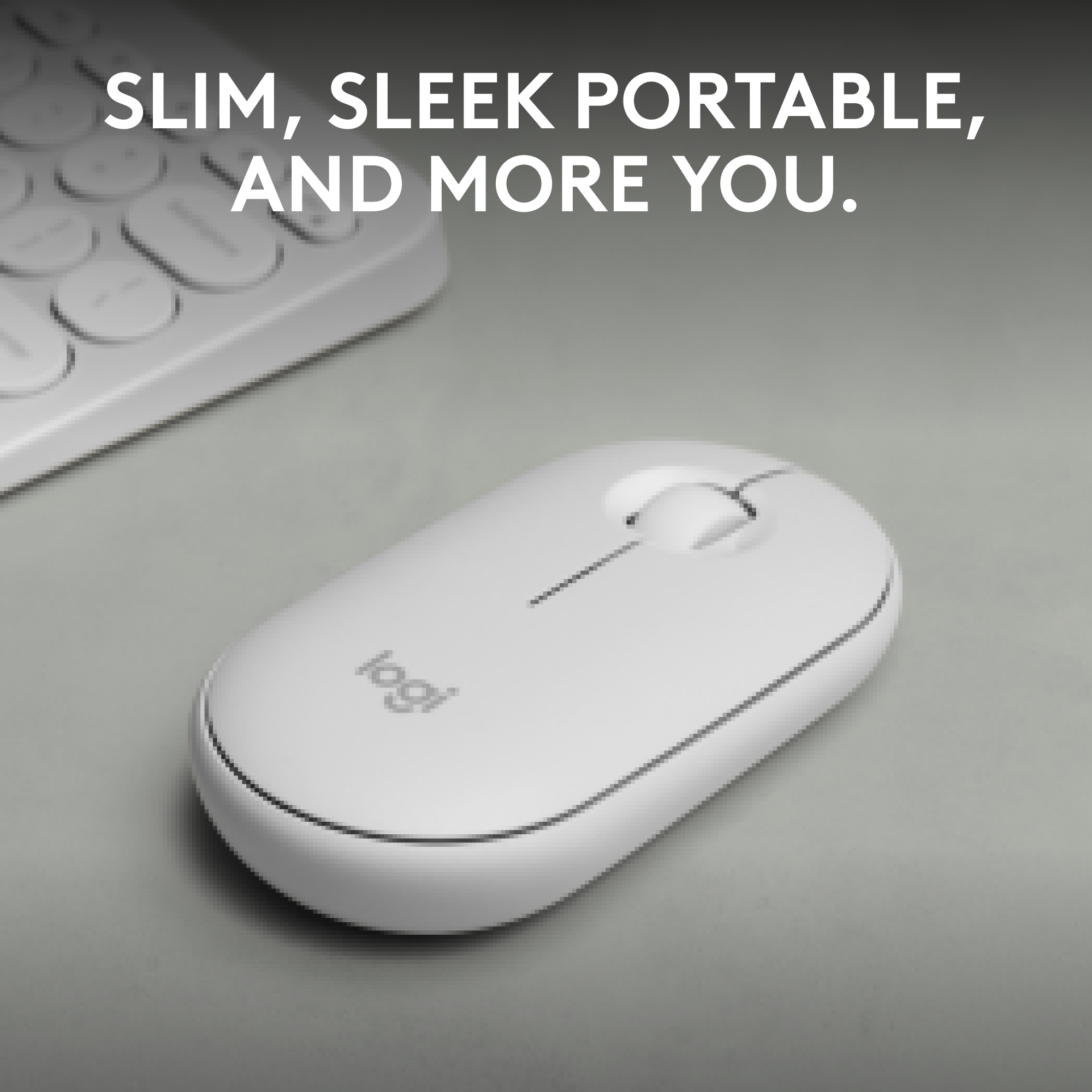 Souris Logitech blanche sur surface grise avec clavier.