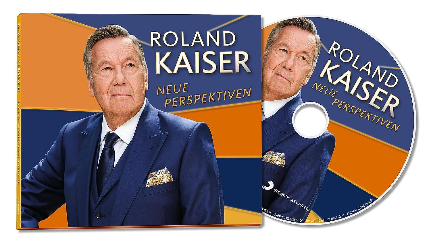 Mann im blauen Anzug hält CD-Album von Roland Kaiser.
