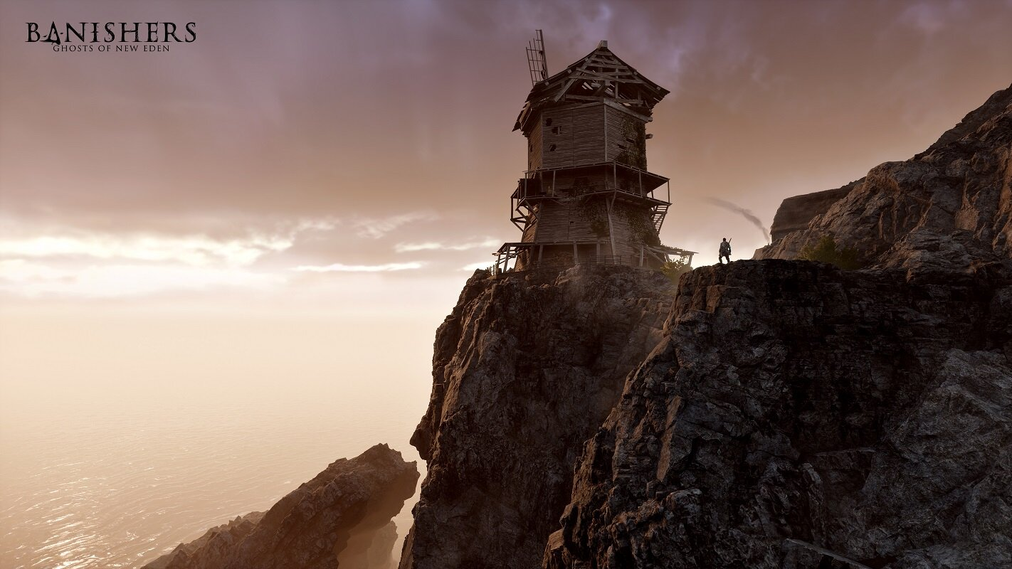 Kamienna wieża na krawędzi klifu, z osobą stojącą na szczycie.