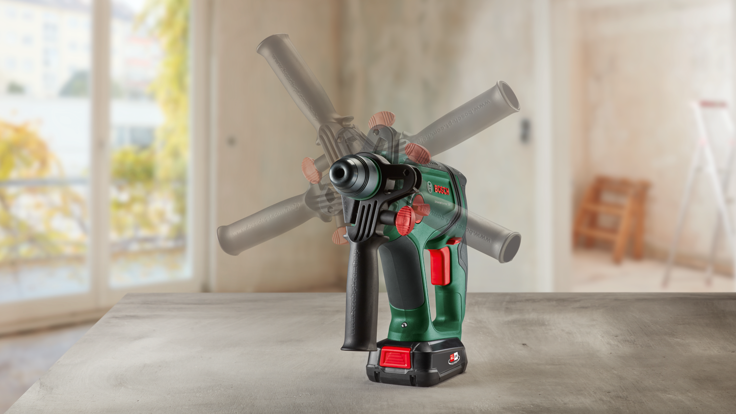 Bosch fúró a asztalon. Sötétzöld és fekete test, piros részletek, elmosott háttérrel.
