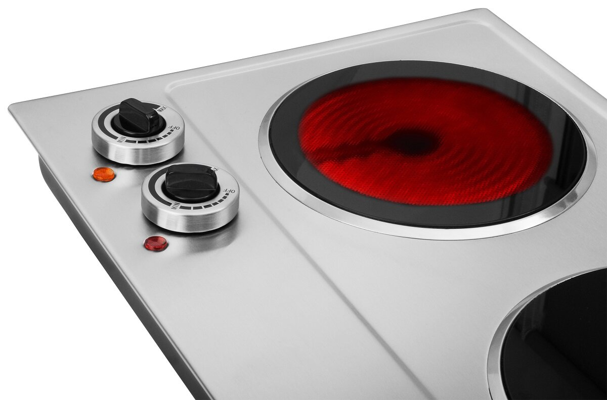 Płyta elektryczna z dwoma palnikami. Jeden palnik świeci na czerwono. Widoczne są pokrętła.