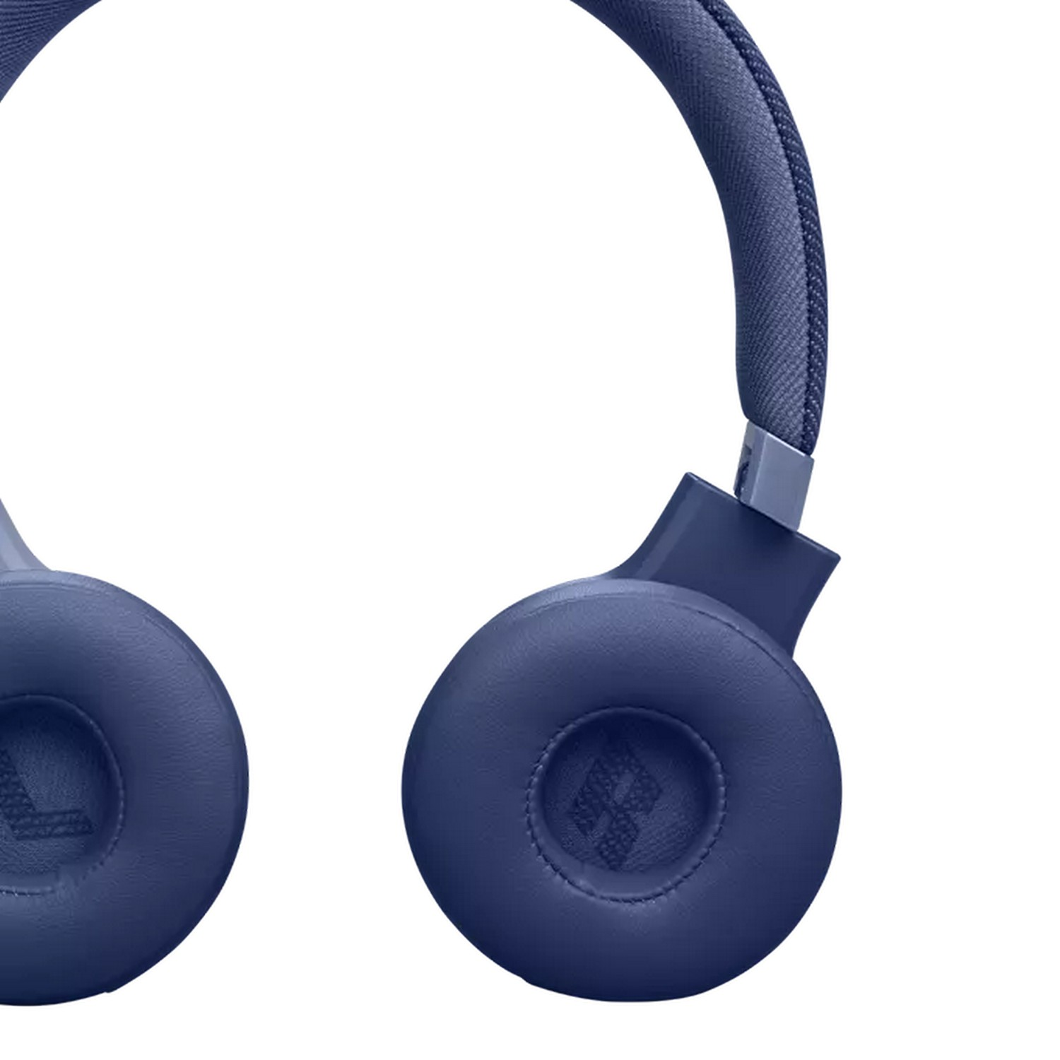 Close-up of navy blue JBL headphones. White background. Focus on the ear cup.