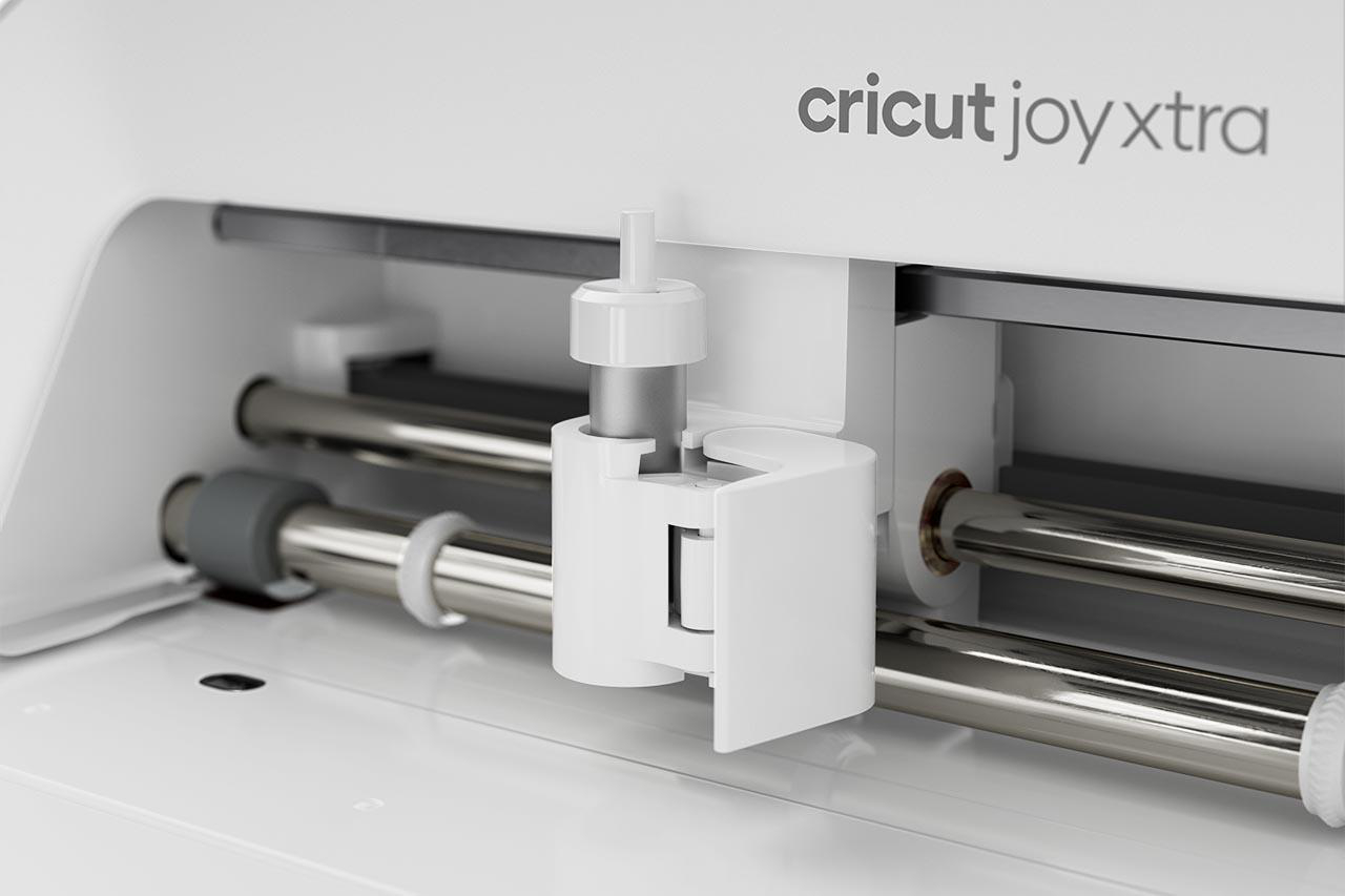 Nahaufnahme einer weißen Cricut Joy Xtra Maschine. Silberstangen und ein weißer Schneidekopf sind sichtbar.