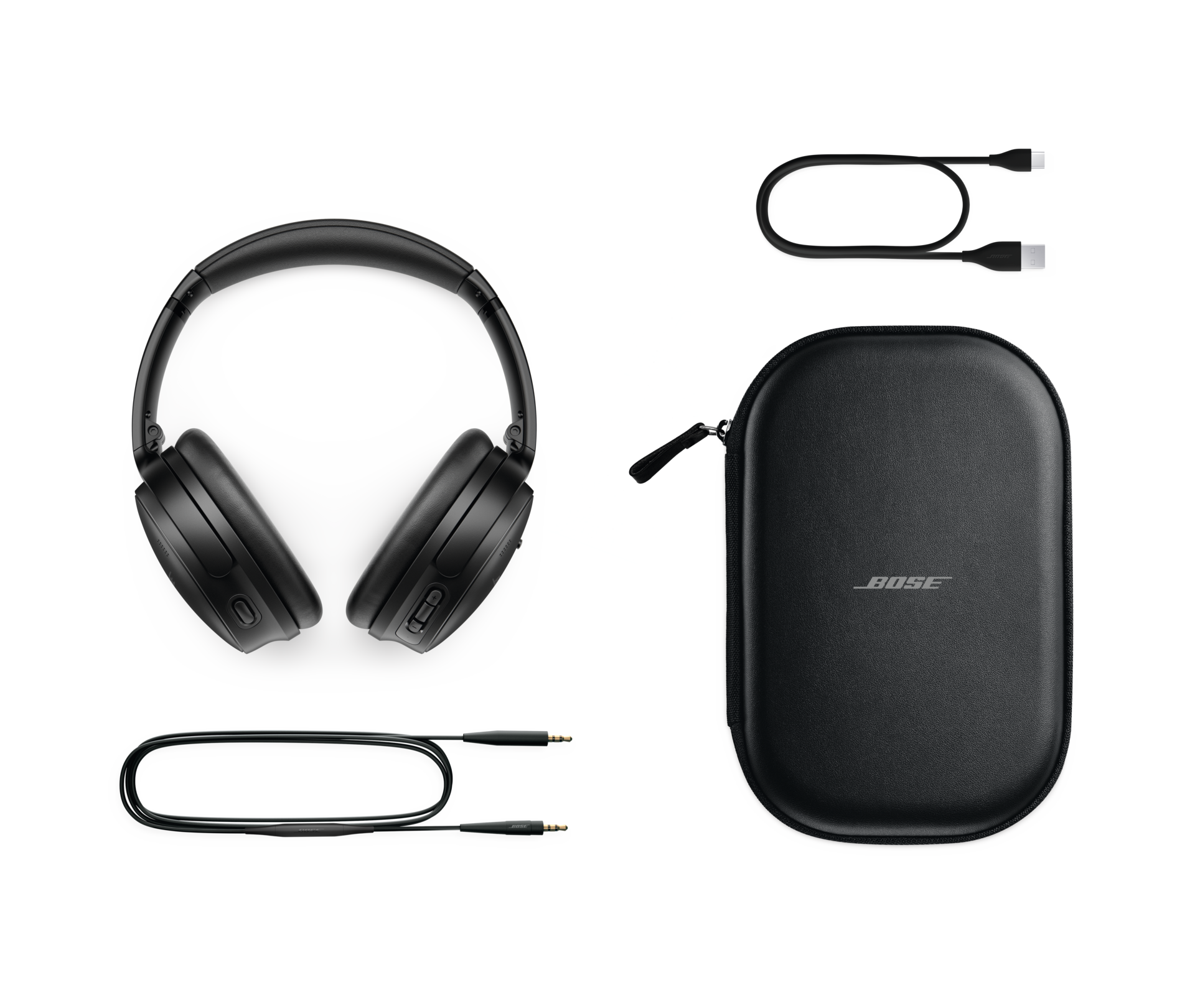 Schwarze Bose-Kopfhörer, eine Hülle und zwei Kabel vor schwarzem Hintergrund.