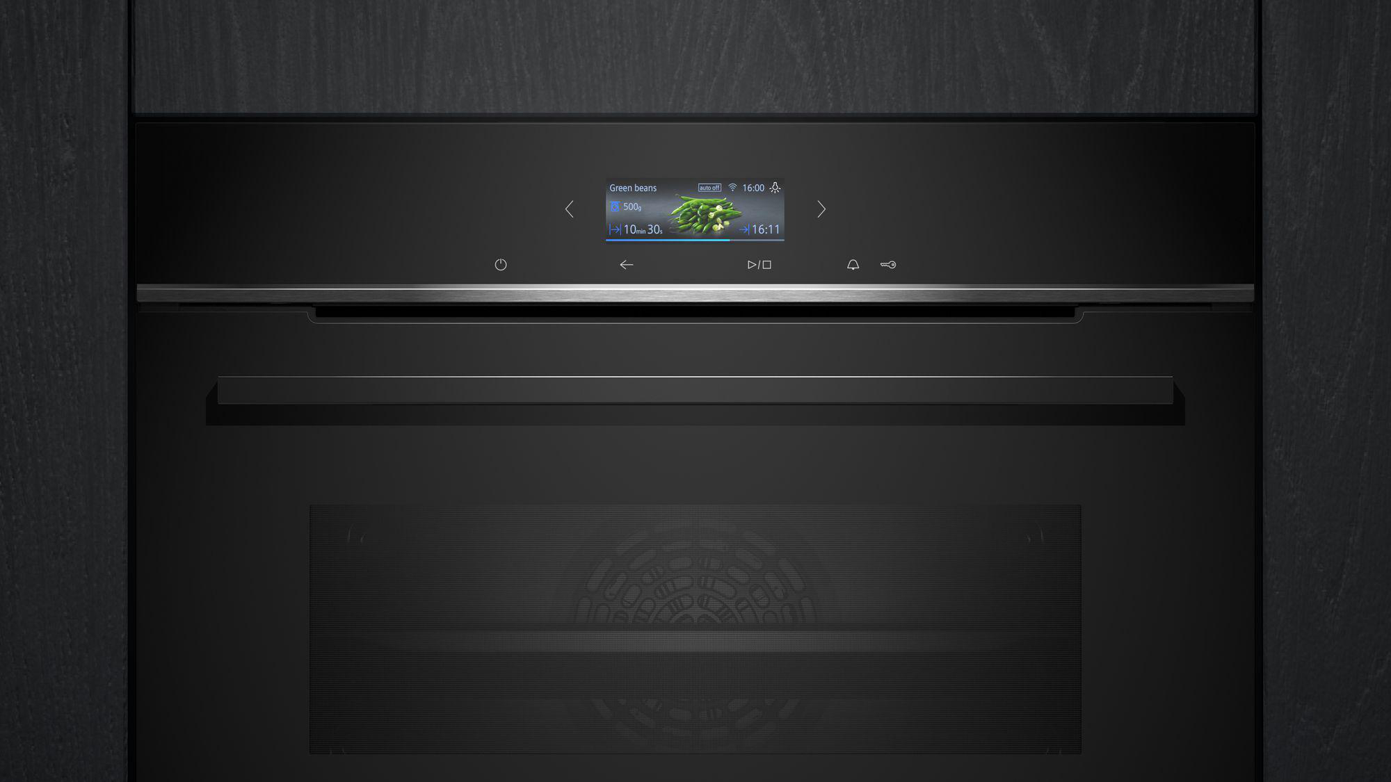 Schwarzer Einbaubackofen mit Gemüseanzeige. Dunkles, modernes Kücheninterieur.