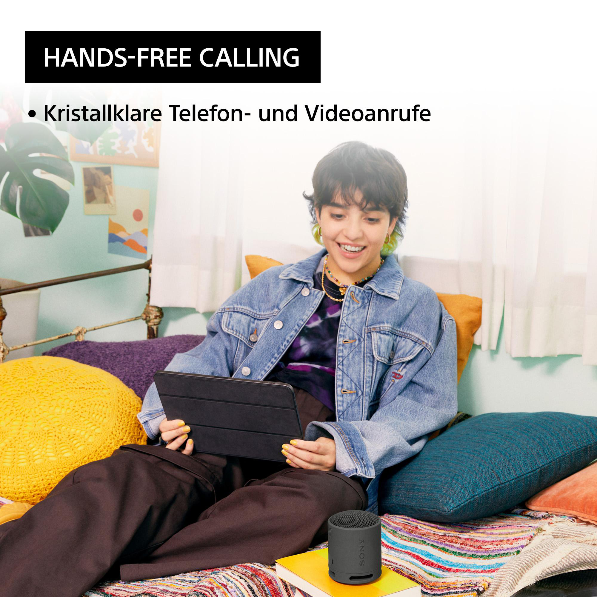 Eine Frau benutzt ein Tablet, ein kleiner Lautsprecher steht auf einem Bücherstapel. Text: 'Hands-Free Calling'.