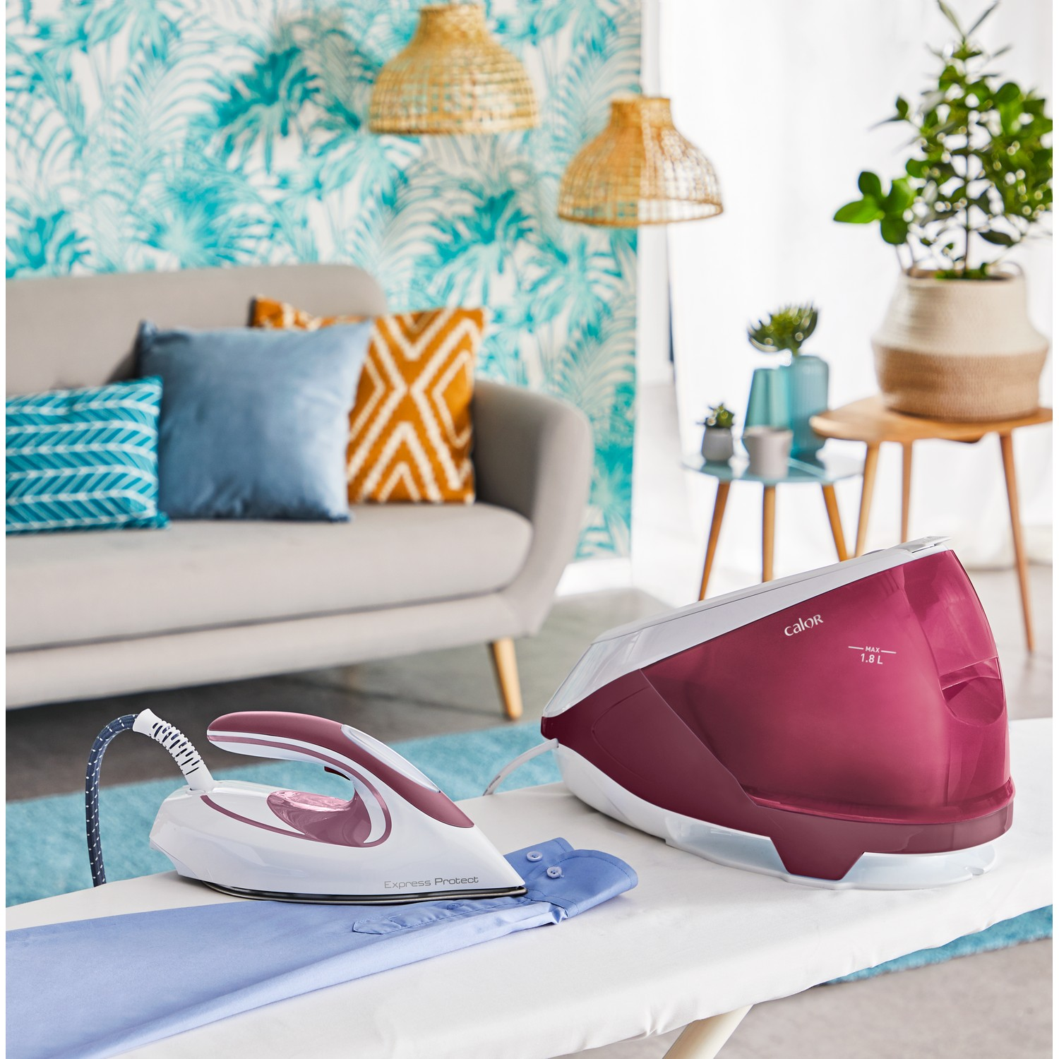 Ironing setup with a white iron on a blue shirt, next to a maroon steam generator.