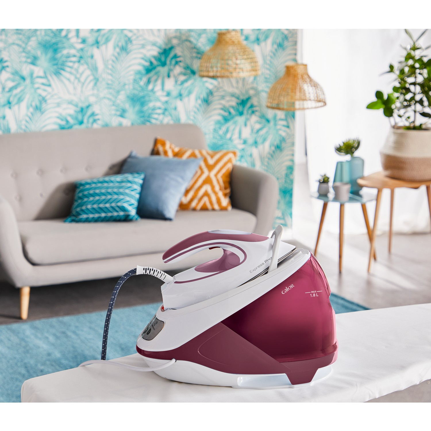 A steam iron on an ironing board, with a sofa and decor in the background.