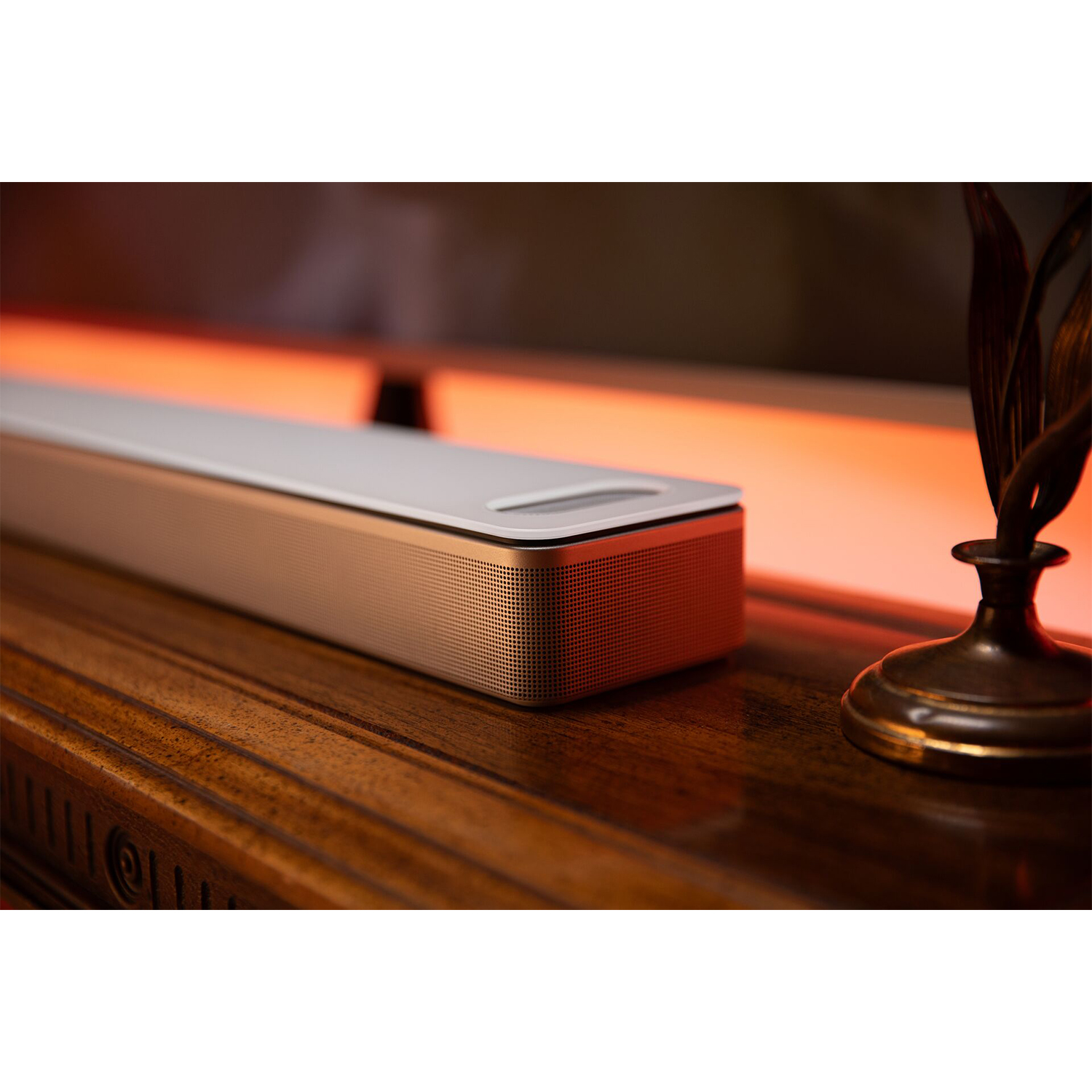Primo piano di una soundbar su superficie in legno, sfondo sfocato.