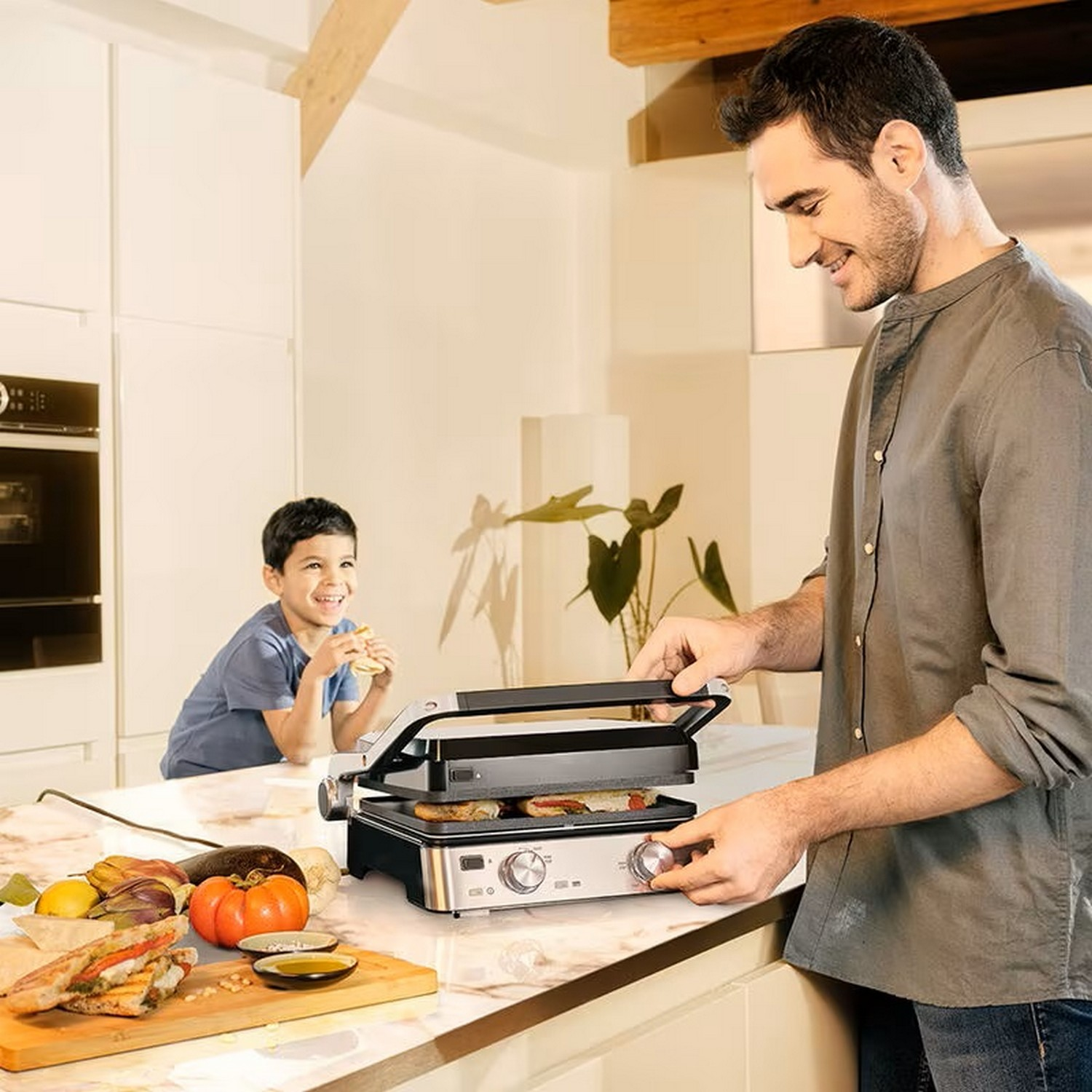 Un homme grillant un sandwich, un garçon mangeant, cuisine avec des ingrédients. Un homme prépare de la nourriture avec un grill.