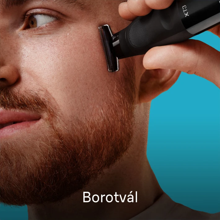 Férfi fekete trimmerrel borotválkozik. Vörös szakáll, kék háttér.