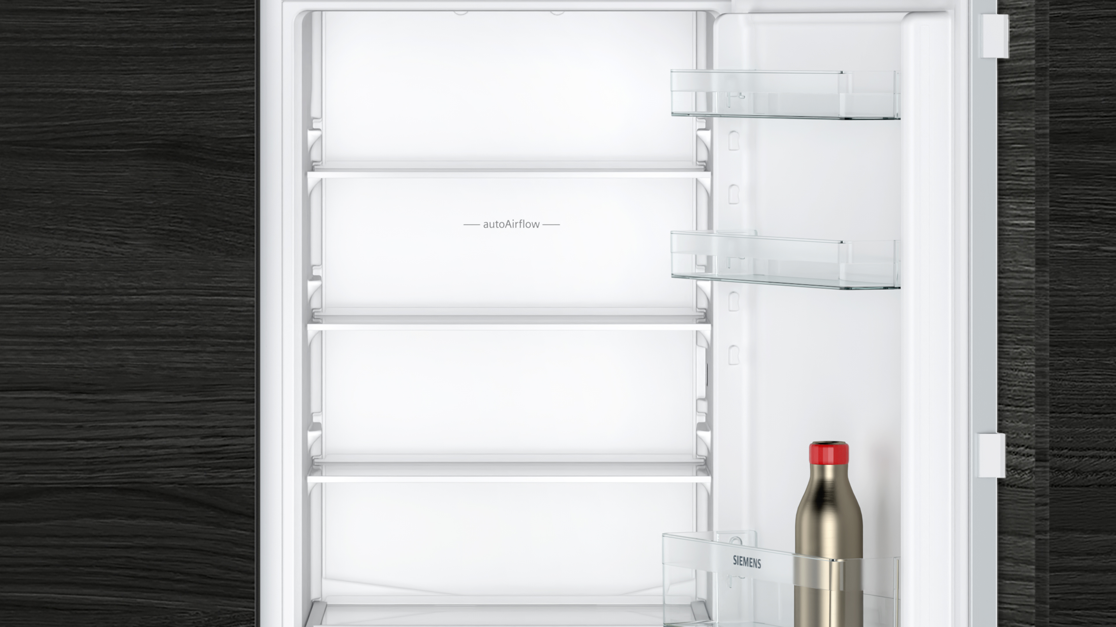 Leeres weißes Kühlschrankinnere mit Glasböden, autoAirflow. Eine Flasche mit roter Kappe steht unten.