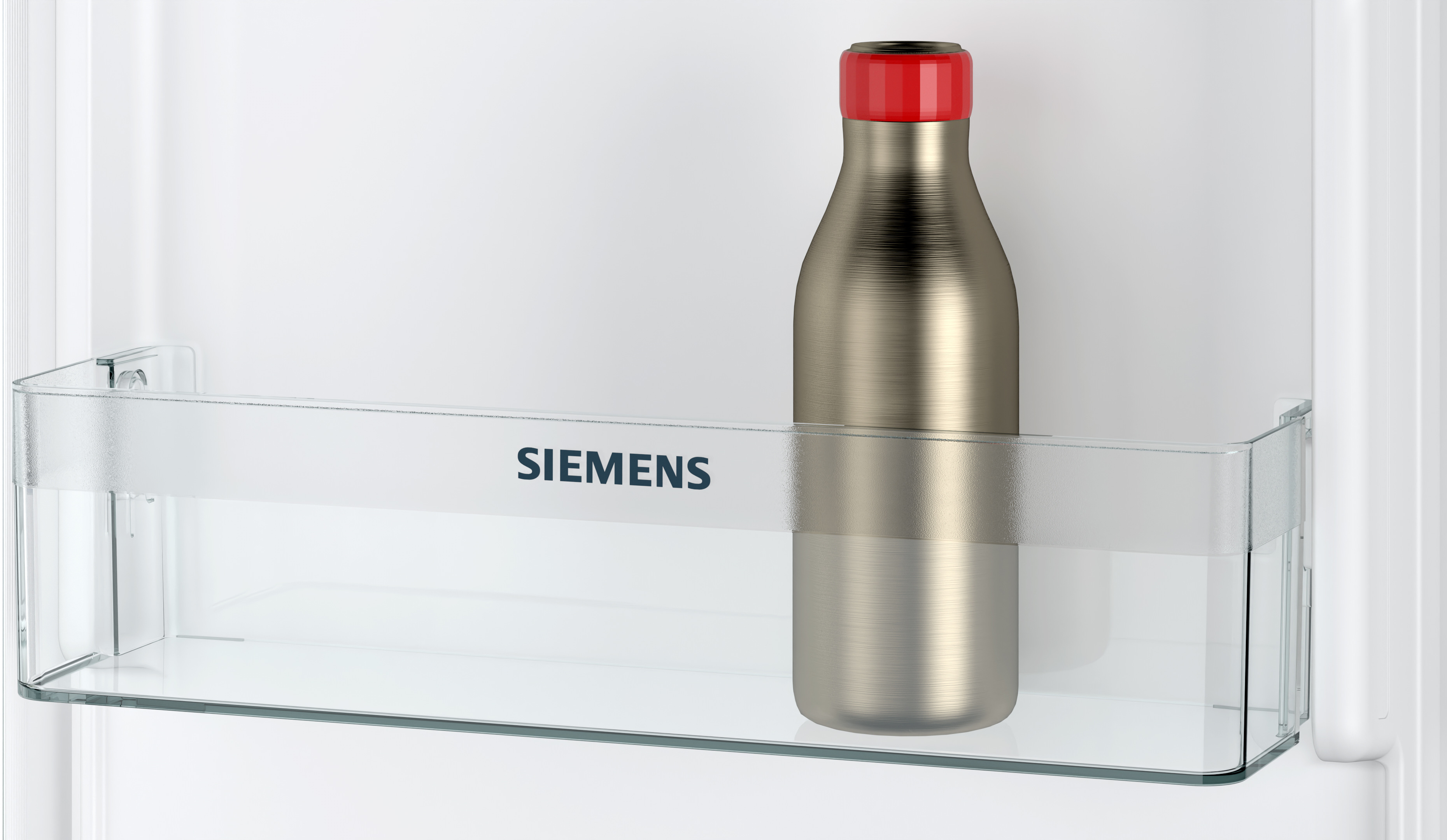 Eine Edelstahl-Wasserflasche mit rotem Deckel in einem Kühlschrankregal.