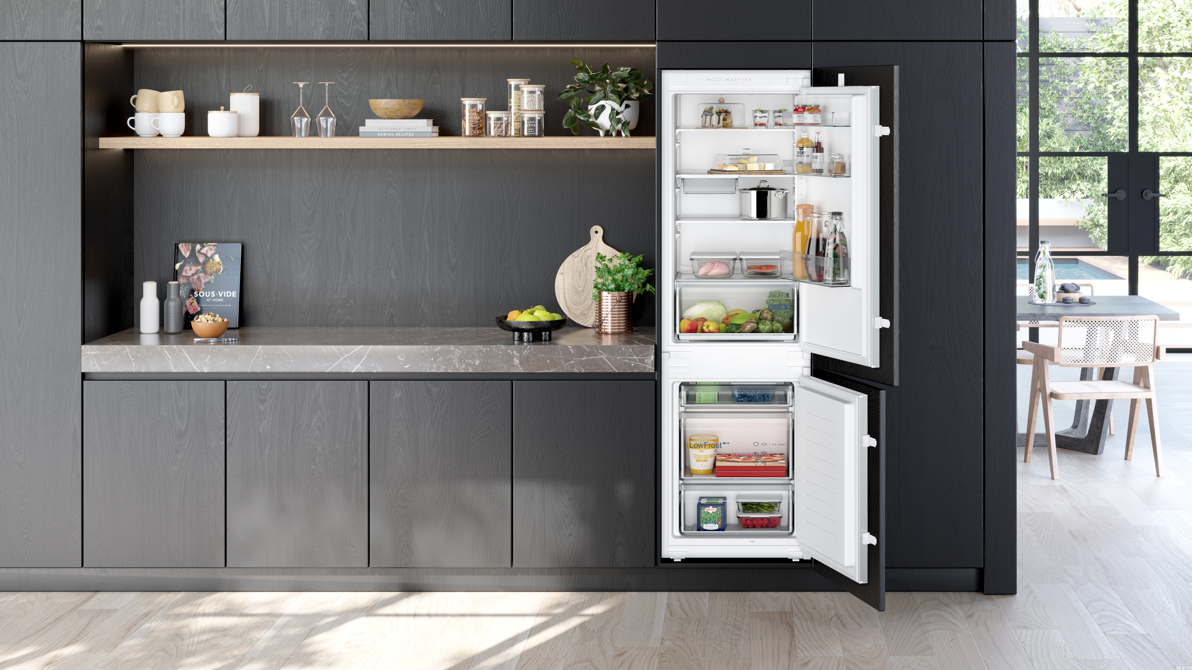 Offener Kühlschrank in moderner Küche. Lebensmittel sind sichtbar. Küchenzeile mit Deko.