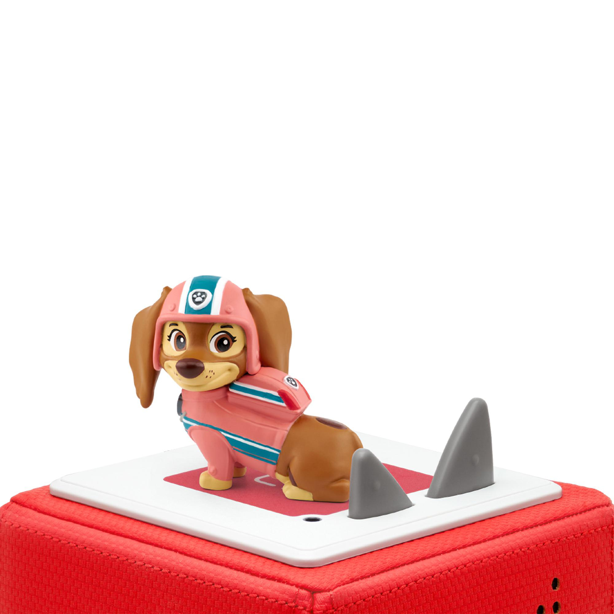 Spielzeug Hund in rosa Anzug und Helm, stehend auf roter und weißer Plattform mit Haifischflossen.