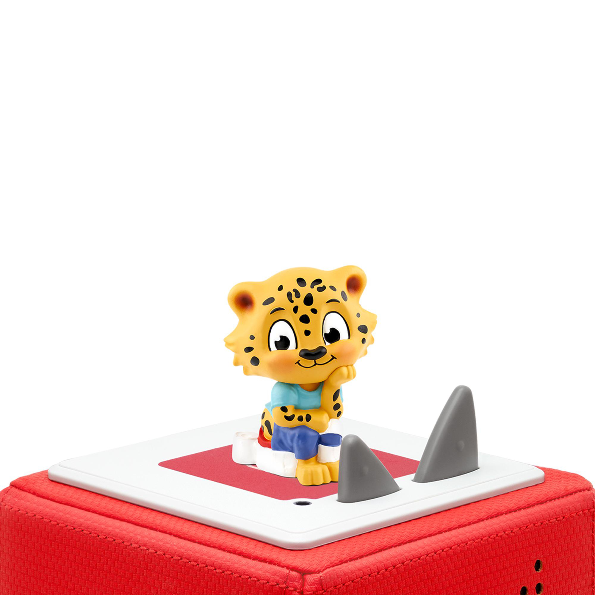 Leopard-Spielzeug auf einem roten Würfel, mit grauen Haifischflossen.