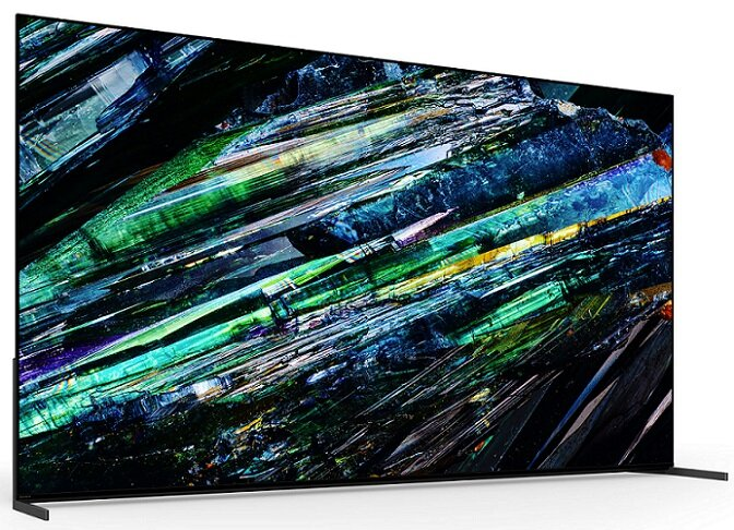 Nowoczesny ekran telewizora z abstrakcyjną grafiką, przedstawiający zielone, niebieskie i żółte wzory krystaliczne.