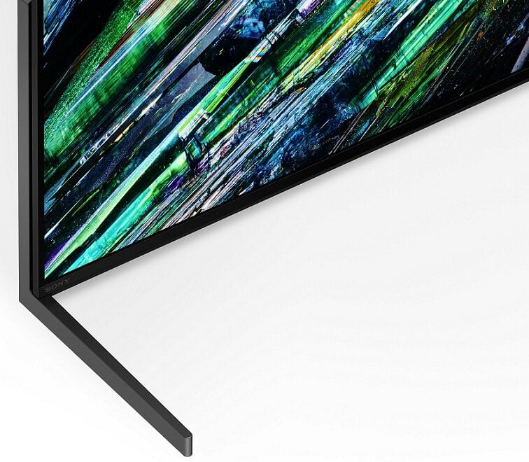 Zbliżenie podstawy telewizora i dolnego rogu ekranu telewizora. Ekran wyświetla kolorowe grafiki.