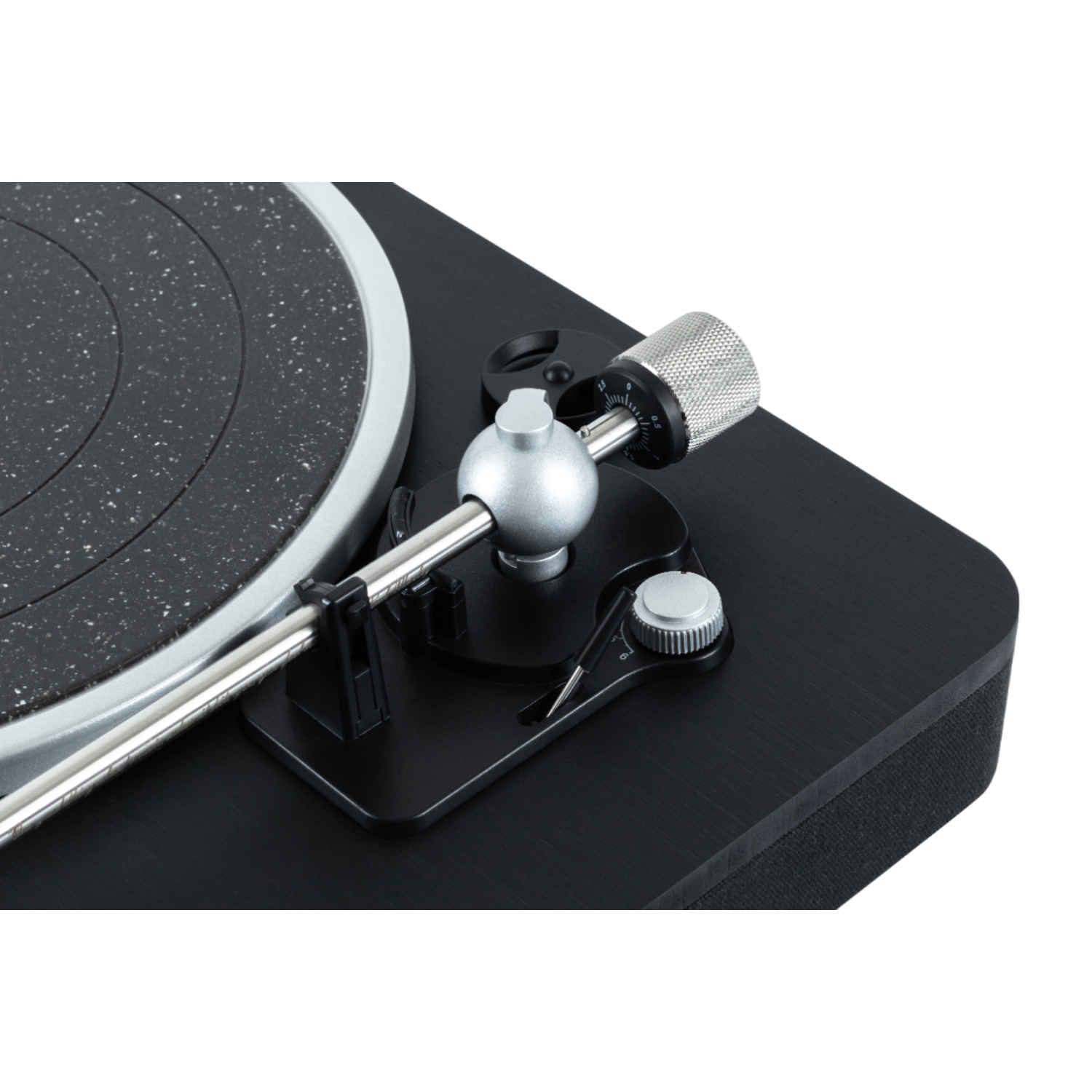 Close-up view of a turntable with a black base. A hand adjusts the tonearm.