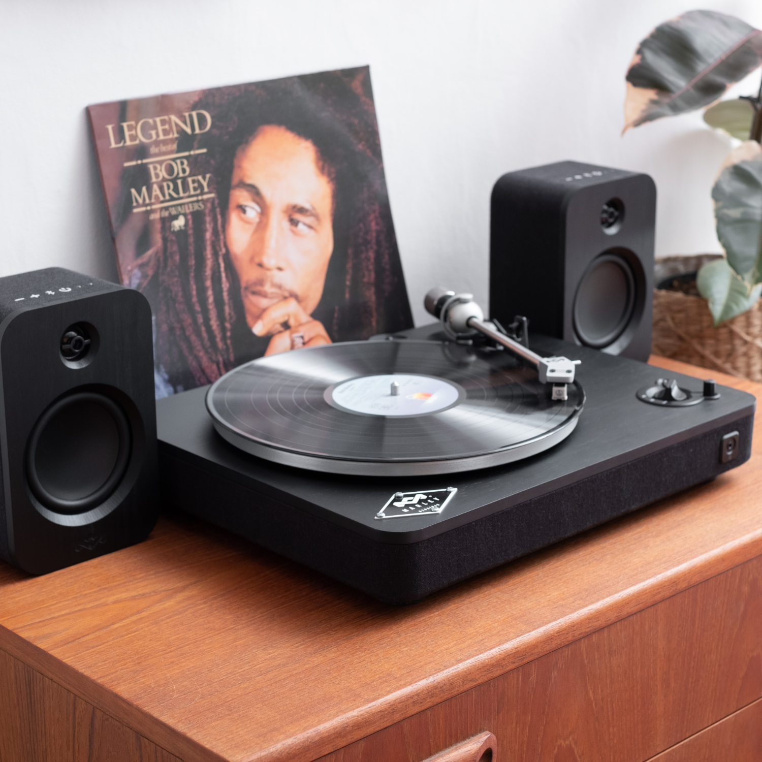 Record player with Bob Marley album, speakers, and other music related items.
