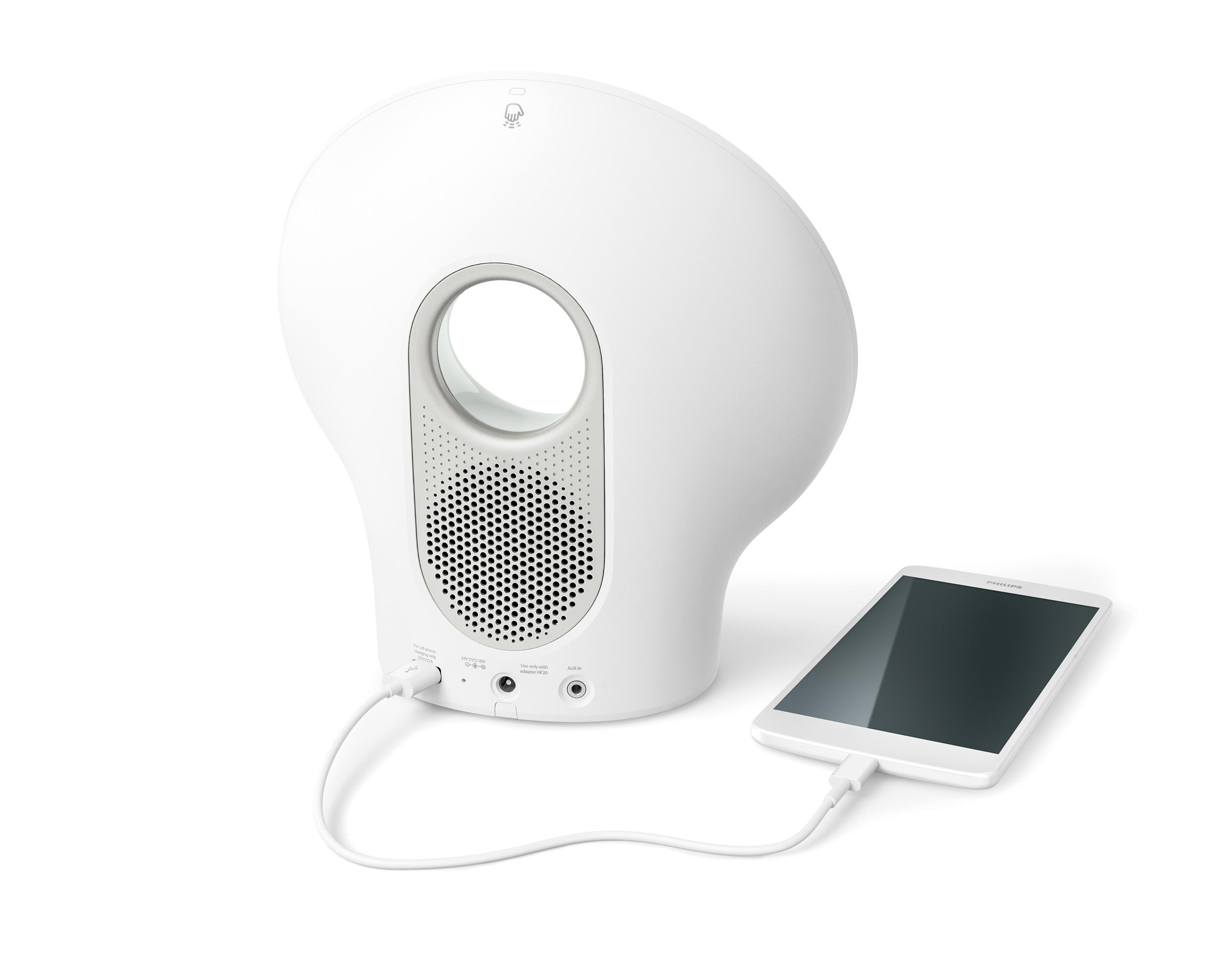 Ein weißer, eiförmiger Lautsprecher und ein Tablet, verbunden durch ein Ladekabel.