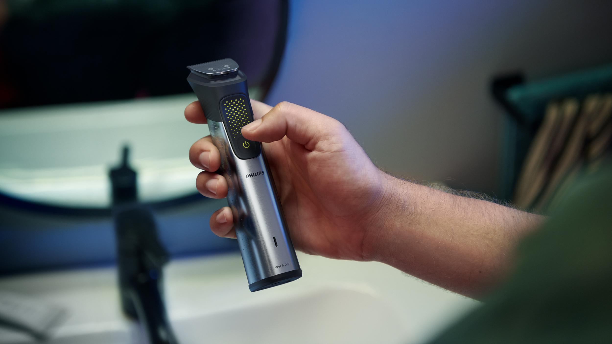 Eine Hand hält einen silbernen und schwarzen Philips Barttrimmer. Der Hintergrund ist unscharf.