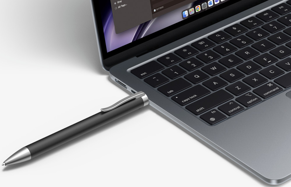 A pen connected to a laptop via USB, with a close-up view.