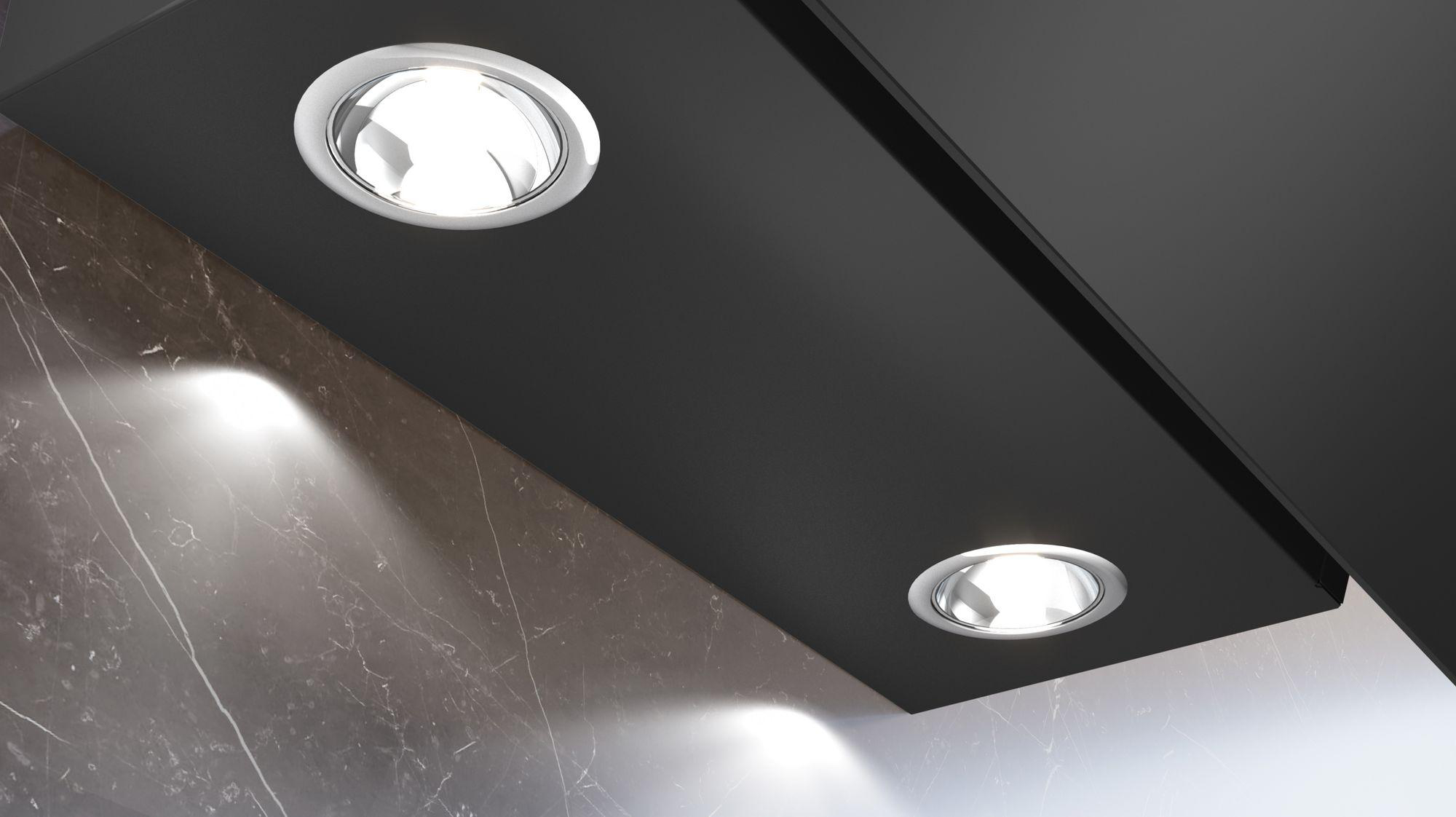Zwei Einbaustrahler in einer schwarzen Decke. Die Lichter sind an und der Hintergrund ist Marmor.