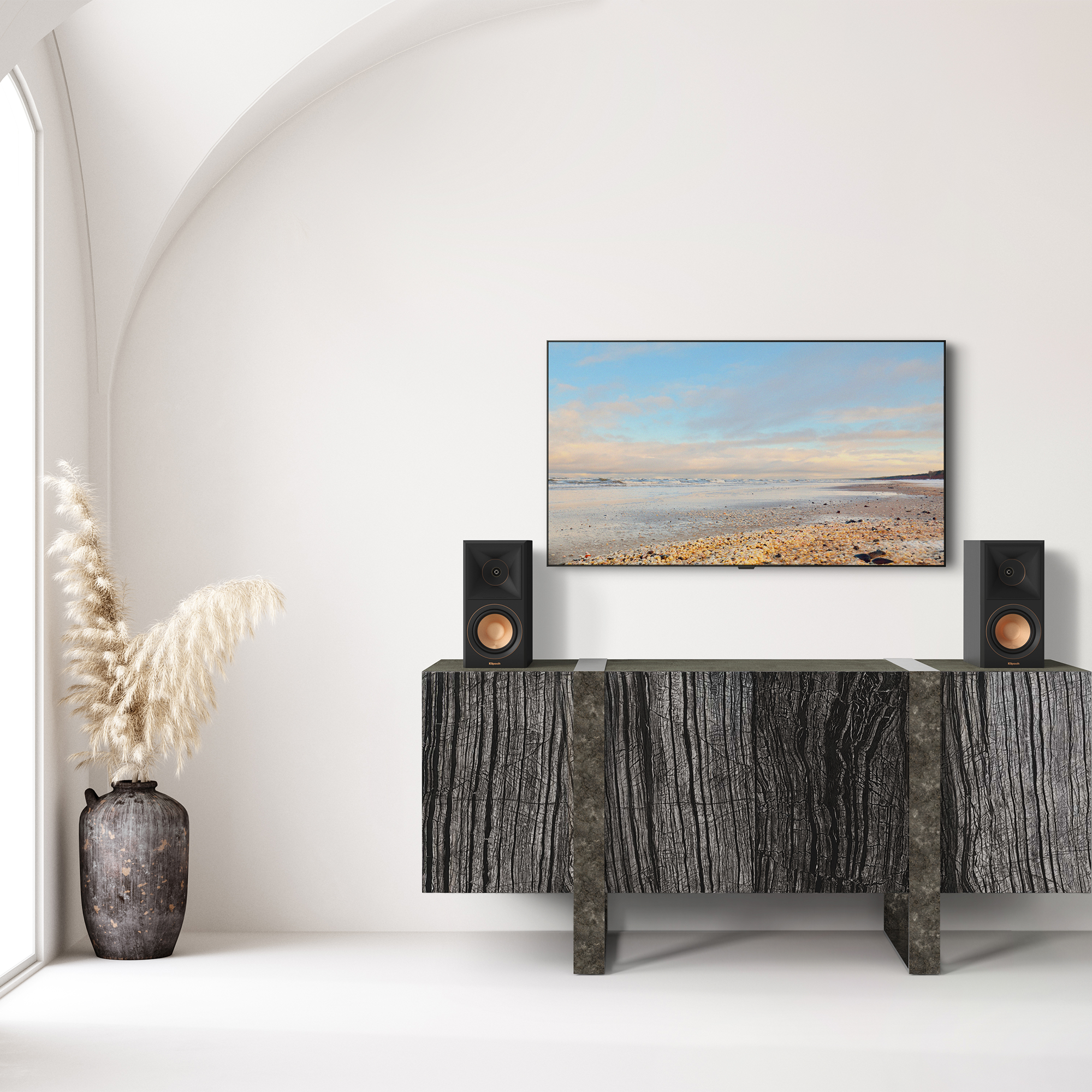 Wohnzimmer-Setup mit Strand-TV, Lautsprechern und Holzschrank. Weiße Wände.