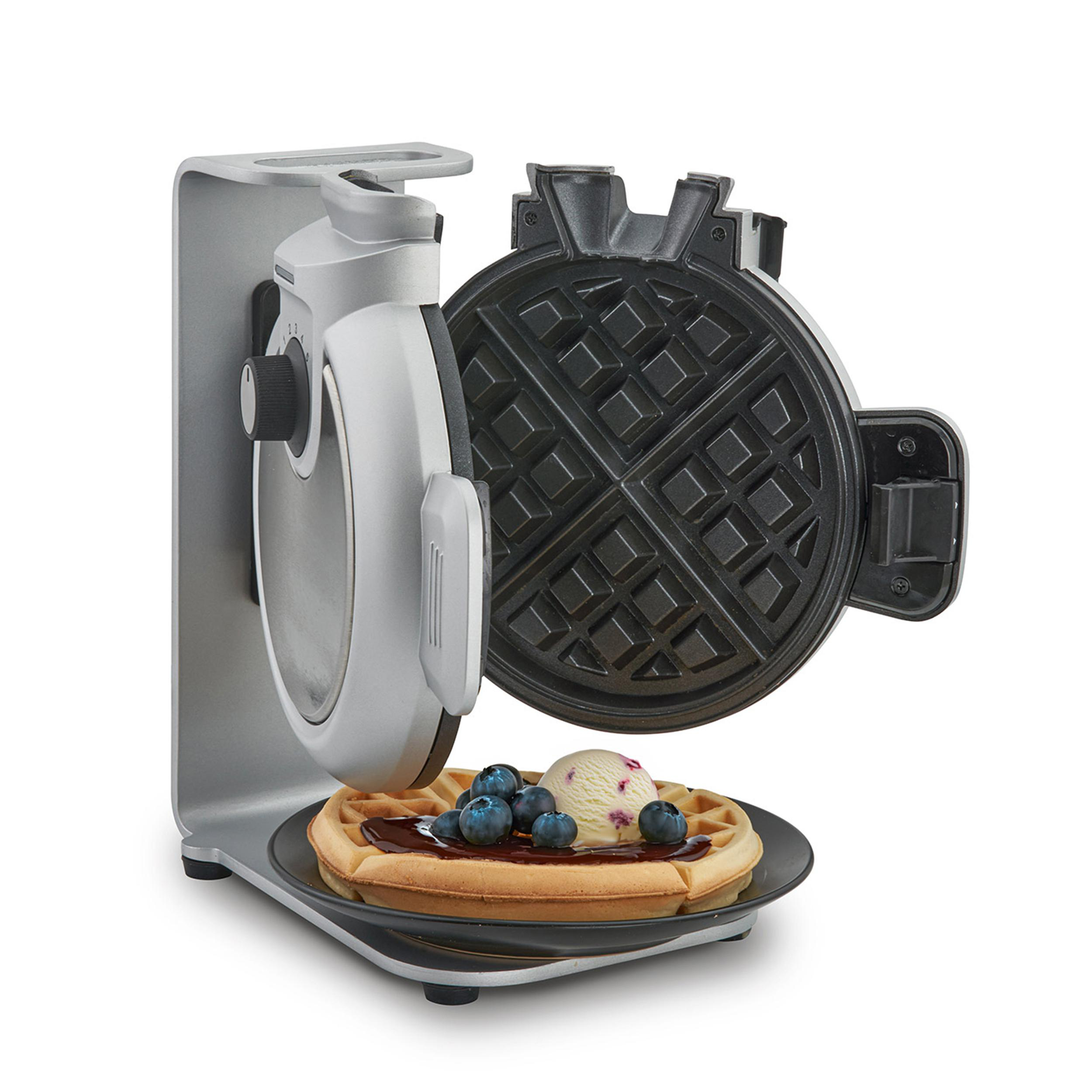Ein Waffeleisen mit einer Waffel, belegt mit Sirup, Blaubeeren und Eis.