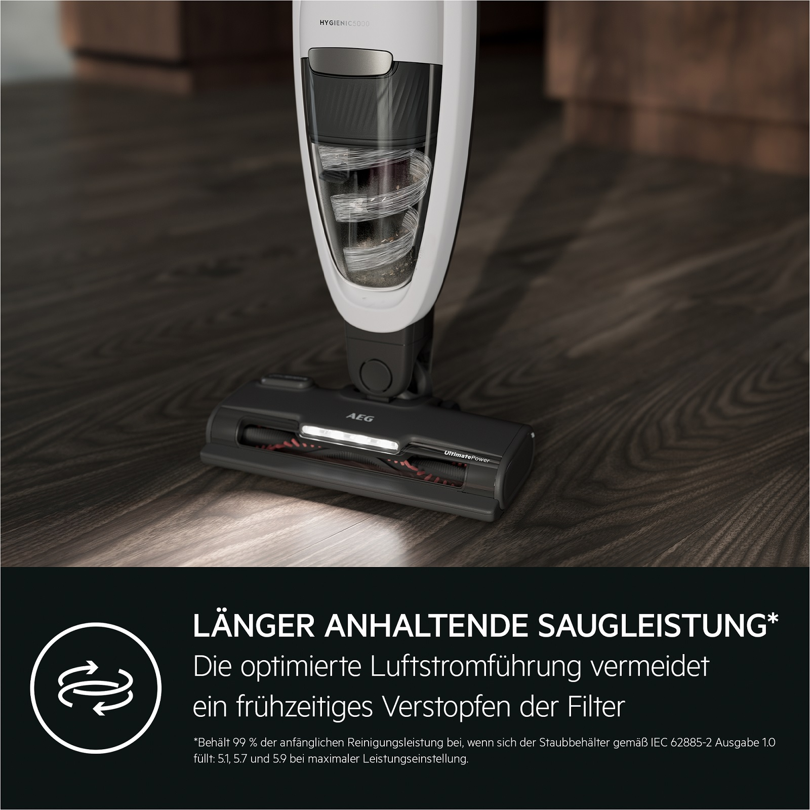 Weiß-grauer Staubsauger. Der Staubsauger steht auf einem Holzboden. Text unten.