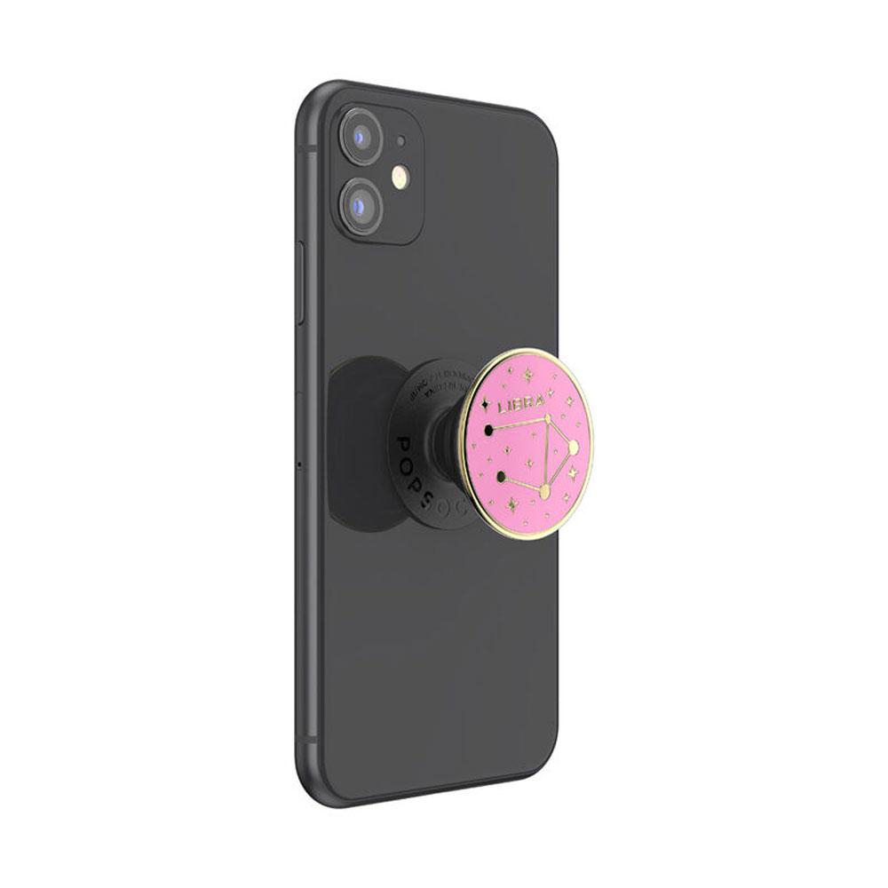 Ein schwarzes Smartphone mit einem pinken Waage PopSocket, das das Waage-Sternzeichen zeigt.
