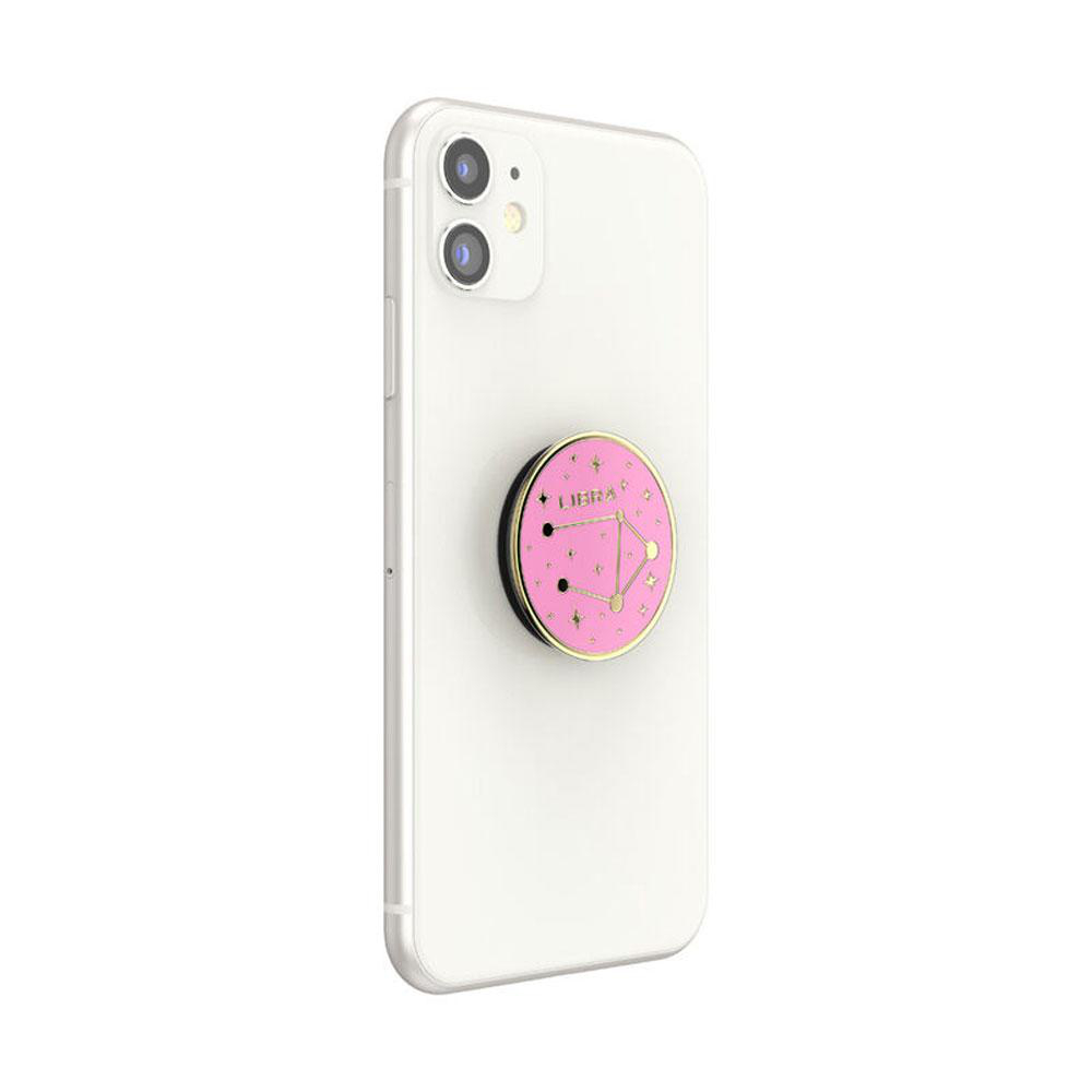 Ein weißes Telefon mit einem pinkfarbenen Libra PopSocket auf der Rückseite. Das PopSocket hat Sterne.