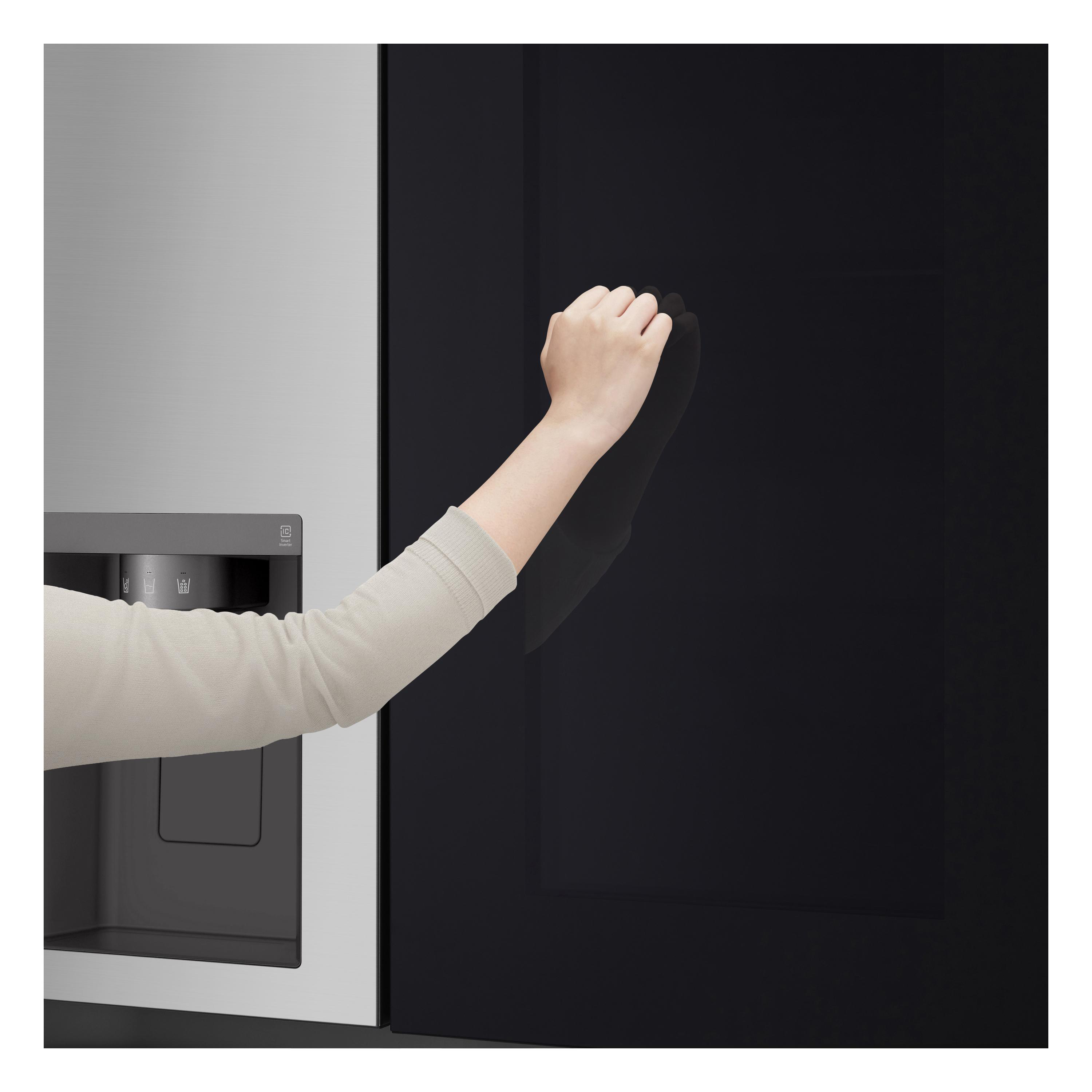 Eine Hand berührt eine schwarze Kühlschranktür. Der Kühlschrank ist aus Edelstahl und schwarz.