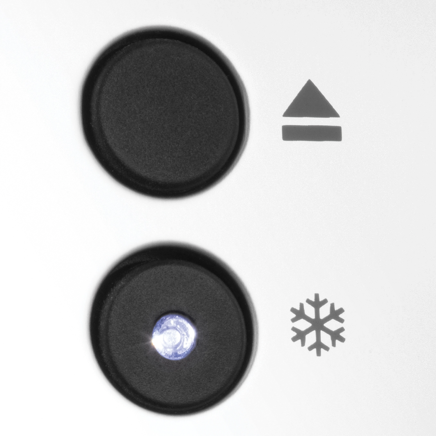Close-up of two black buttons and a snowflake icon on a white surface.