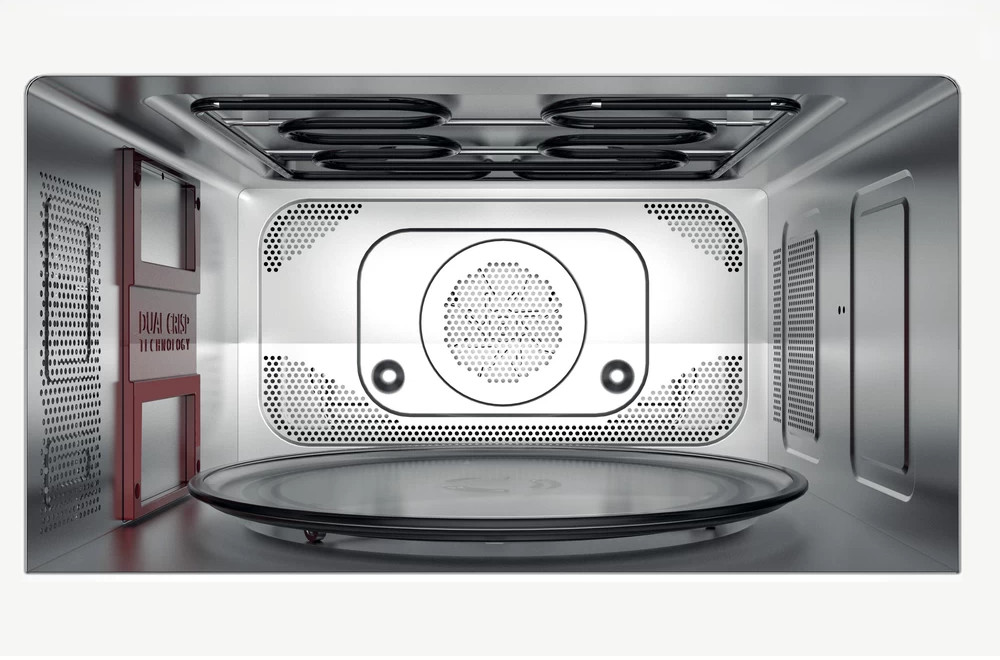 Inside of a microwave oven showing a glass plate and heating elements.
