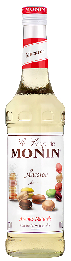 Flasche Monin Macaron Sirup mit weißem Etikett und roter Kappe, Makronen im Hintergrund.