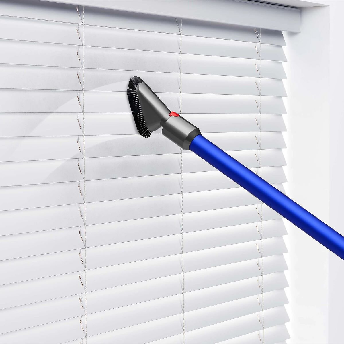 Niebieski odkurzacz z szczotką czyszczący białe żaluzje.