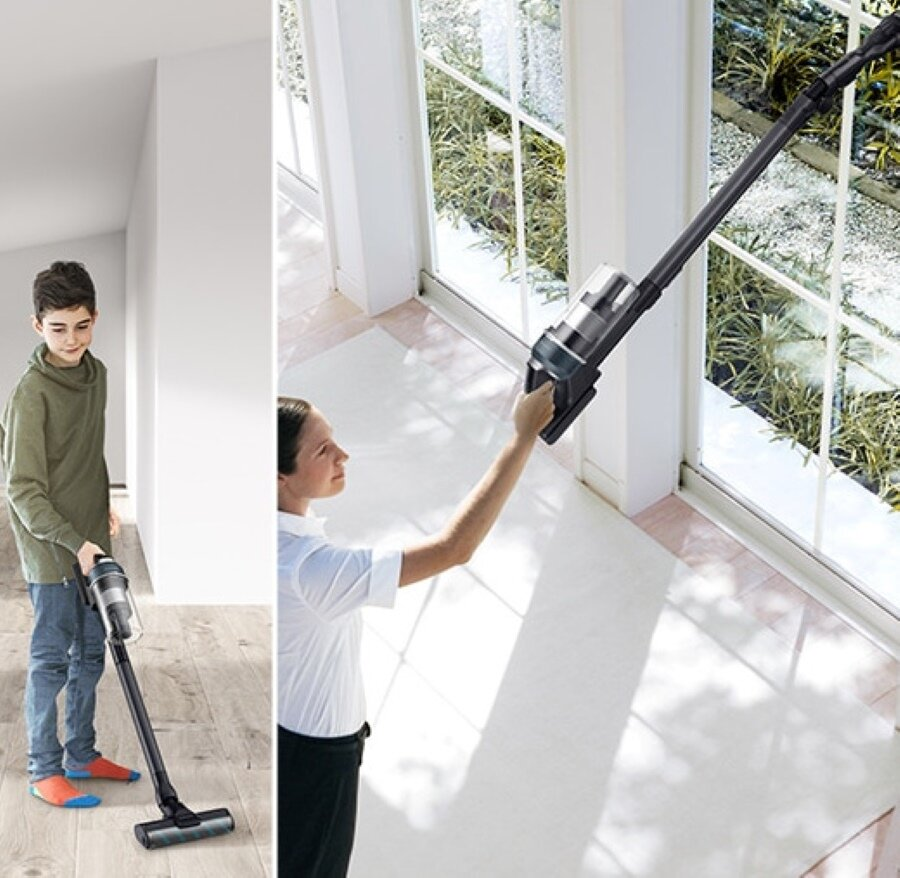Kobieta i chłopiec używają odkurzacza w domu.