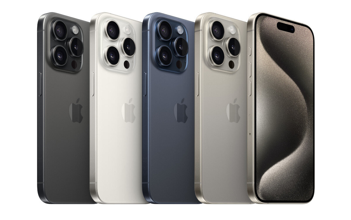 Rząd czterech modeli iPhone 15 Pro w różnych kolorach, pokazujący aparat.